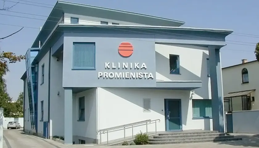 Nowoczesny budynek kliniki z napisem "KLINIKA PROMIENISTA" i logo.